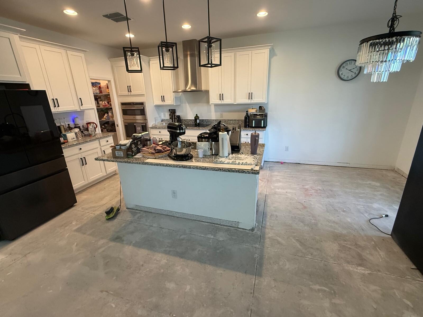 Kitchen with large island and appliances prepped for flooring installation
