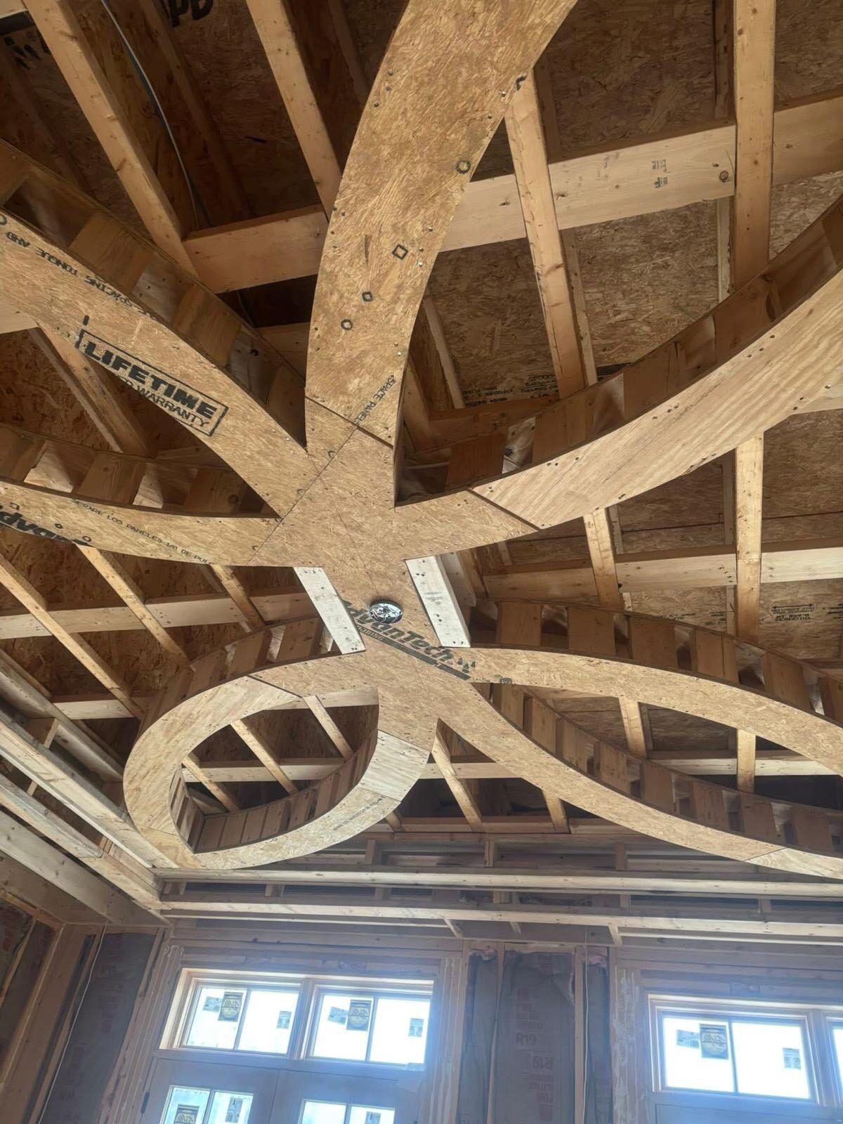 Intricate wooden framework for a custom circular ceiling design in a new build