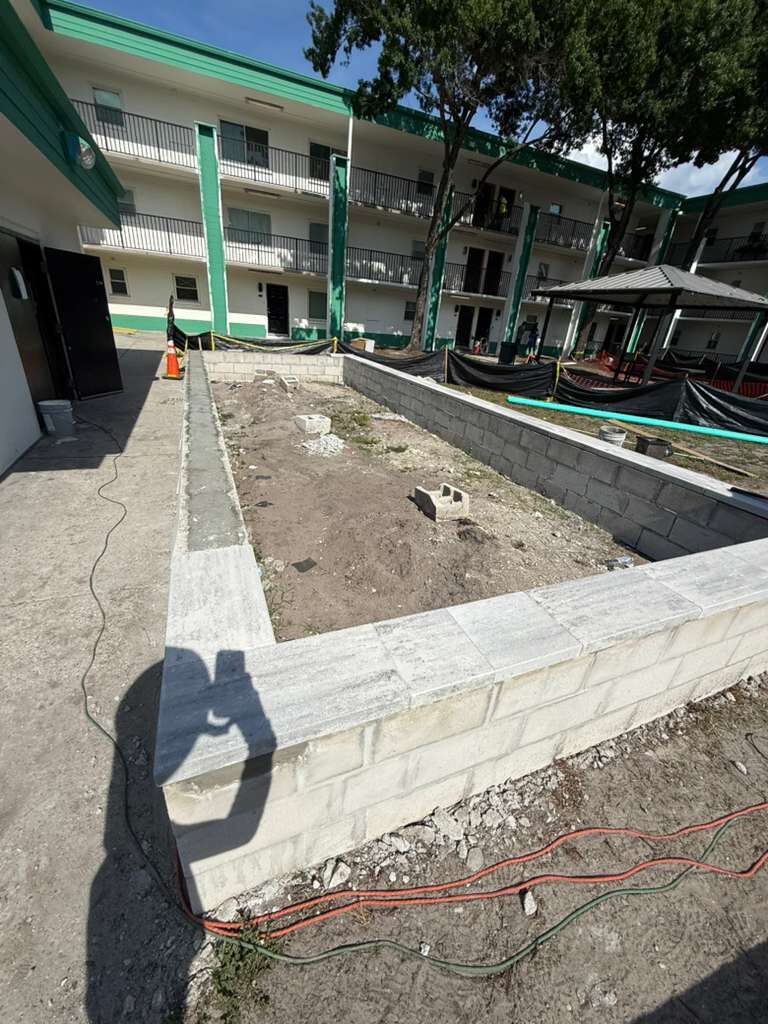 Building exterior renovation with shadow of worker and retaining wall