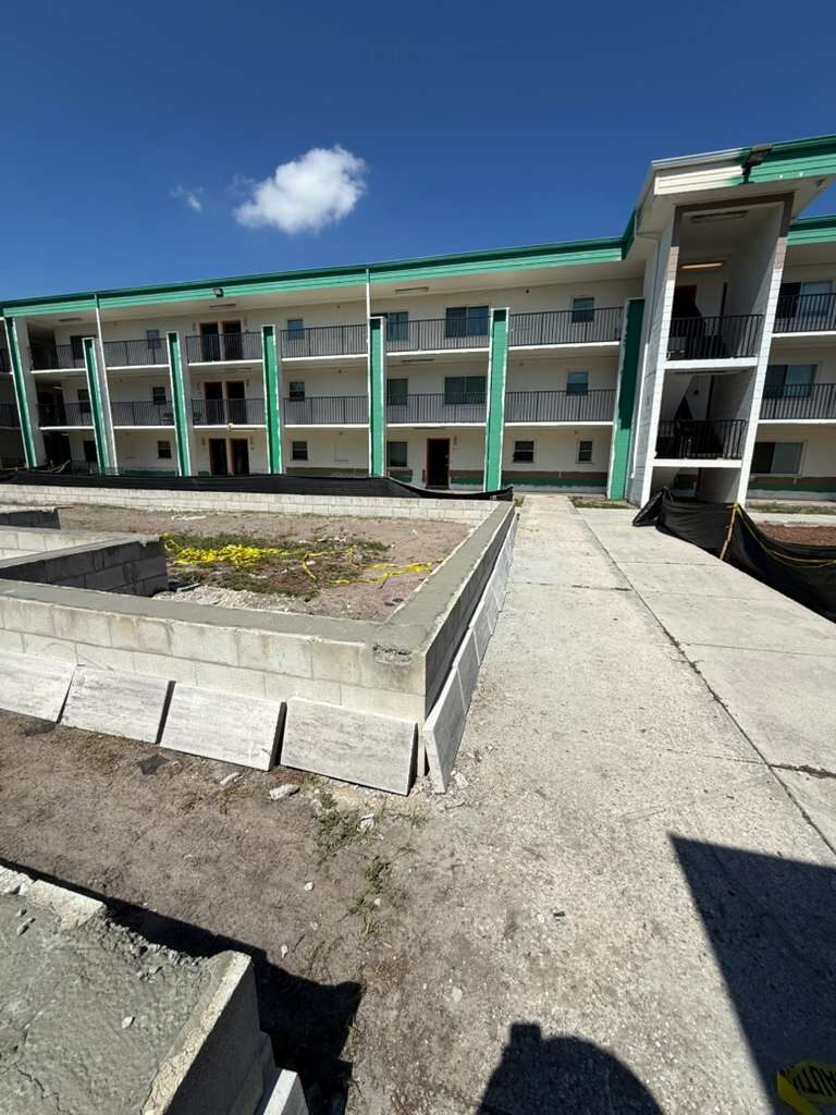 Exterior view showing concrete block walls under construction with multi-story buildings