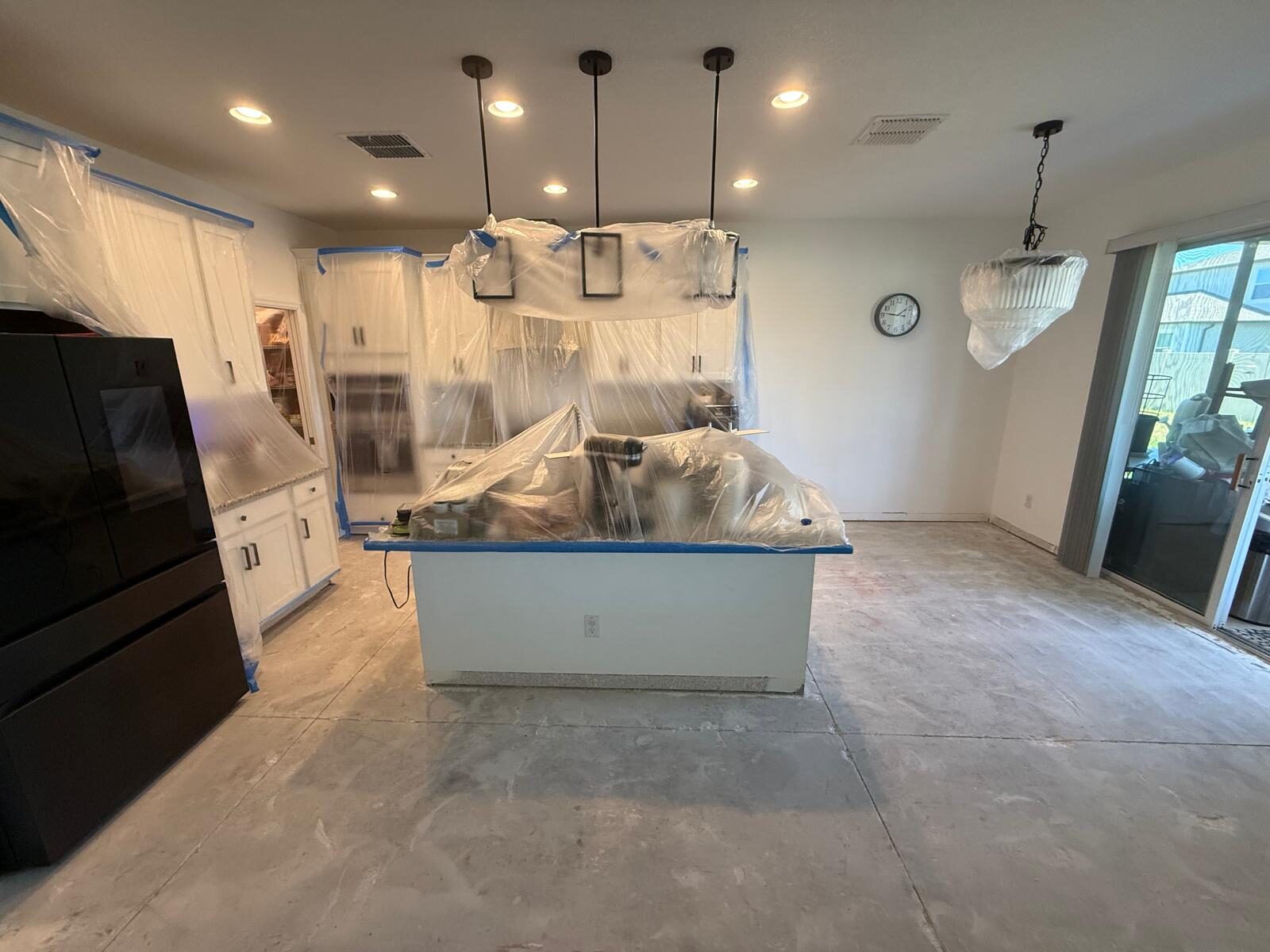 Kitchen cabinets and island covered for protection during interior painting