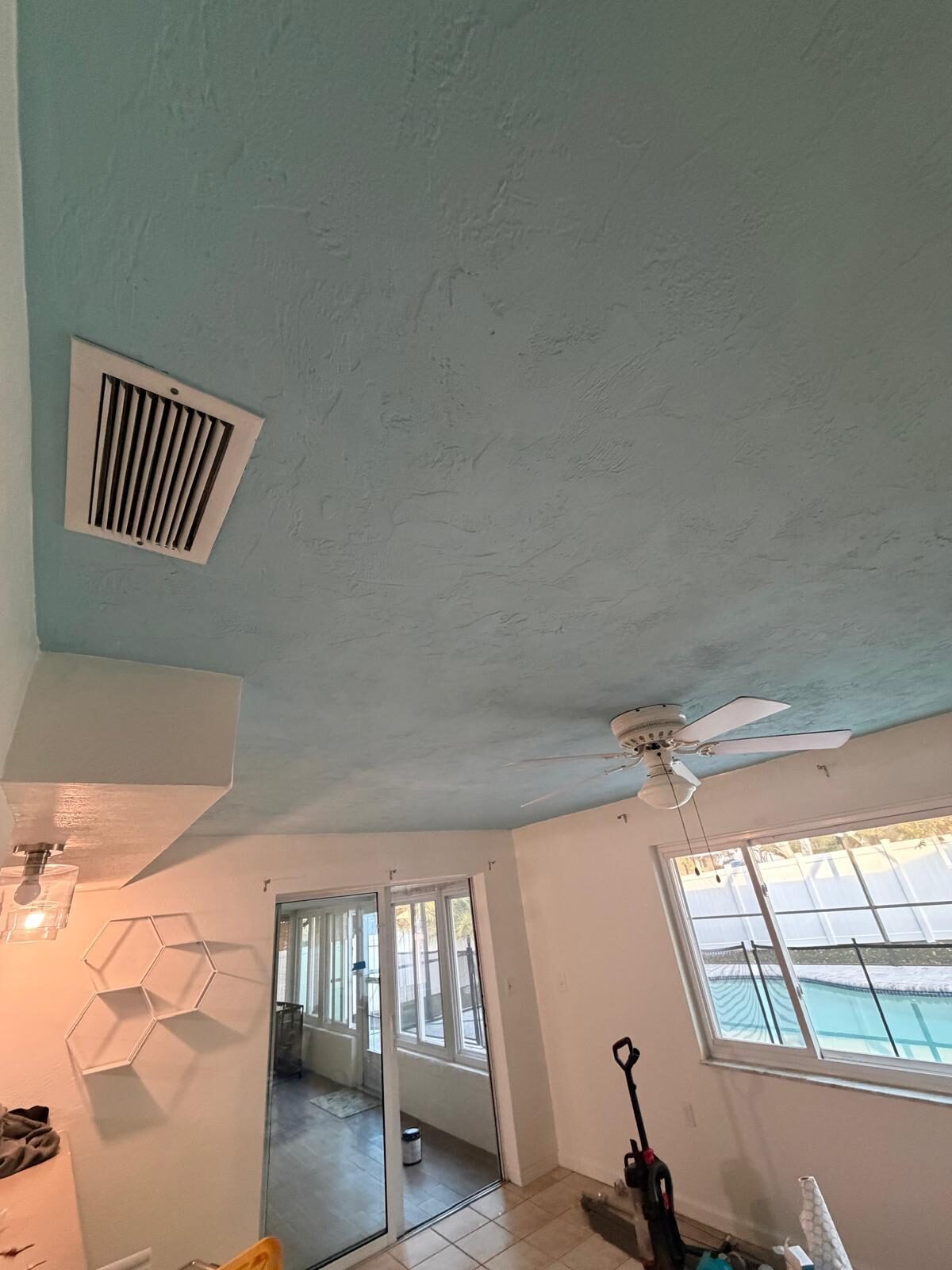 Room with light blue painted ceiling, white walls, and a ceiling fan