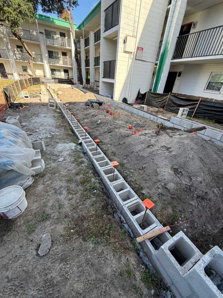 Foundation work for a new exterior wall using concrete blocks and rebar