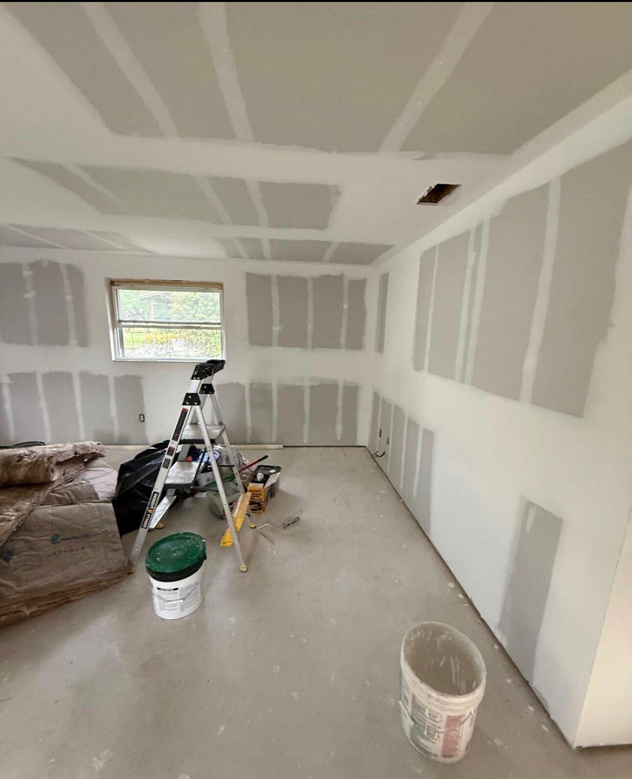 Room with new drywall installed and joints taped, ready for finishing
