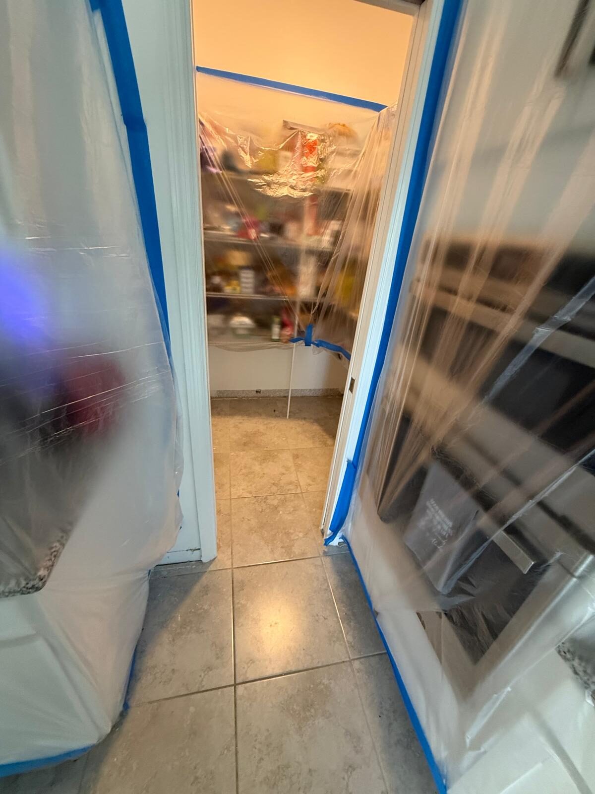 Kitchen pantry protected by plastic sheeting during home renovation
