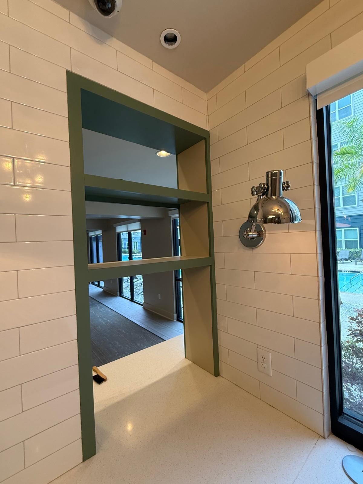 Built-in shelving and white tile walls in a newly constructed commercial kitchen area