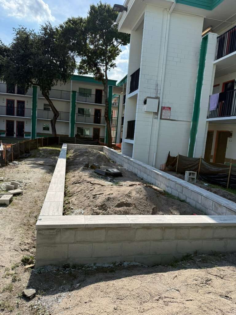 Building exterior with landscaping retaining wall under construction